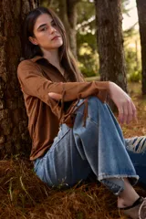 Camisa de color camel con cuello camisero y mangas largas que presentan aberturas laterales con tiras para anudar.