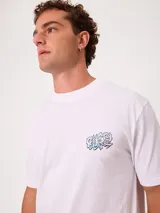 Remera negra de ajuste holgado con gran estampado gráfico en la espalda de temática tropical con una playa, palmeras y la inscripción "Welcome to Surfers Paradise".