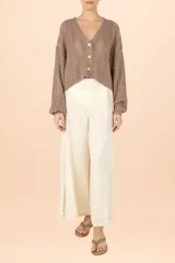 Cardigan de punto color marrón con sutiles destellos brillantes, cuello en V, cierre frontal con botones y mangas largas abullonadas con puños ajustados.