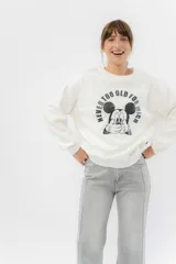 Buzo de cuello redondo en color blanco hueso, con corte relajado y estampa frontal de Mickey Mouse con la frase 'Never too old for Mickey'. Confeccionado en algodón con interior frisado.