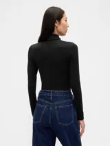 Remera de manga larga con cuello alto tipo polera, confeccionada en tejido suave y ajustado al cuerpo.