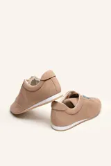 Zapatilla de gamuza color bordó con cordones bicolores, interior de cuero vacuno y suela de caucho blanca y beige.
