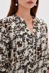 Blusa estampada de viscosa con diseño abstracto en tonos beige, negro y marrón, escote en V con cuello mao y mangas tres cuartos con detalles de lazos en los puños.