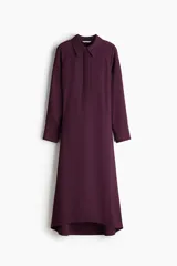 Vestido midi color bordó, con cuello camisero y tapeta con botones ocultos, de manga larga con puños anchos abotonados y corte holgado.