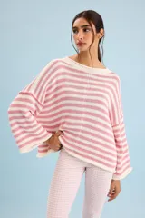 Buzo tejido de algodón con diseño a rayas horizontales en color crudo y rosado, cuello redondo y mangas anchas.