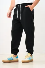 Pantalón de jogging negro con cintura elástica ajustable con cordón, bolsillos laterales y corte tapered.