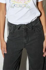 Jean de pierna ancha color gris oscuro, con cintura alta, bolsillos delanteros y traseros con detalle de trenzado, y cinturón de soga.