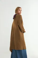 Saco tipo cárdigan largo de tejido de punto, color beige, con diseño abierto sin botones, mangas largas amplias y corte recto.