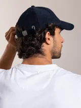 Gorra de pana color camel con visera curva y logo bordado en el lateral.