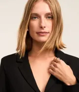 Vestido corto negro de crepé con poliéster certificado RCS, cuello blazer, mangas largas y cinturón de material sintético con hebilla metálica.