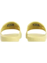 Ojotas tipo slide de Calvin Klein, color amarillo pálido. Presentan una suela moldeada ergonómica con soporte para el arco plantar y una capellada de doble tira de TPU con diseño en relieve y el logotipo de Calvin Klein grabado.