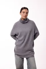 Sweater de punto color gris, con cuello polera amplio y diseño oversize de silueta fluida y caída liviana.