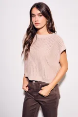 Chaleco sin mangas de tejido de punto color rosado pálido, con textura calada y acabado lurex, corte al cuerpo y cuello redondo.