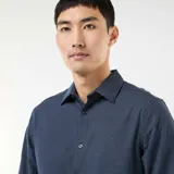 Camisa de manga larga con corte slim, confeccionada en tejido dobby con un sutil patrón geométrico repetitivo en color azul oscuro.