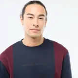 Buzo de cuello redondo con diseño color block en azul marino y bordó. Presenta un estampado minimalista en el pecho y puños acanalados.