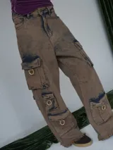 Pantalón cargo oversize de jean con múltiples bolsillos funcionales y detalles metálicos en bronce.