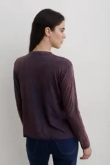 Remera de manga larga con efecto lavado, cuello redondo y estampa frontal con diseño de estrella y texto.
