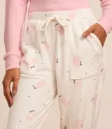 Conjunto de pijama largo de plush, compuesto por remera de mangas largas y cuello redondo, y pantalón con elástico y lazo en la cintura. El pantalón tiene estampado de gatitos y la palabra "lovely".