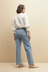 Jean de corte recto confeccionado en denim con spandex, de tiro medio y color azul claro. Presenta un tajo lateral en el ruedo de ambas piernas.