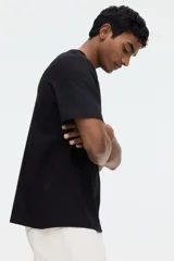 Remera negra de corte estándar y diseño clásico, con cuello redondo y mangas cortas. Confeccionada con fibra COOLMAX que transporta el sudor a la superficie.