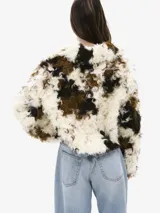 Chaqueta corta de piel sintética con estampado en tonos blanco, marrón y negro, con cierre frontal con gancho metálico.