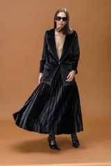 Falda midi plisada de terciopelo negro, con diseño fluido y corte acampanado.