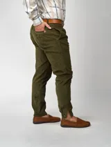 Pantalón de pana negro de corte recto, con bolsillos laterales y traseros. Se ajusta a la cintura con cinturón de cuero negro.