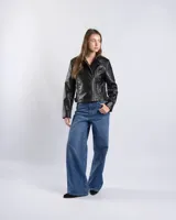 Campera estilo motero de símil cuero color negro, con cuello alto, cierre frontal asimétrico, bolsillos con cierre y detalles acolchados en los hombros.