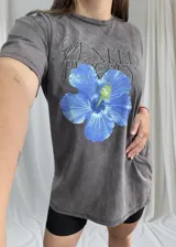 Remerón gris con estampado de hibisco azul y texto en color negro.