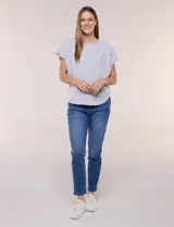 Remera de silueta amplia y relajada de color gris melange, confeccionada en algodón con poliéster. Presenta escote a la base con terminación rústica de borde enrollado, mangas cortas de hombro caído sin dobladillo y ruedo curvo con la parte posterior más larga.