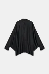 Camisa negra de cuello redondo y manga larga ancha con silueta fluida, con cierre frontal de botones y aberturas laterales en el bajo.