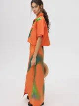 Camisa corta celeste con estampado de nubes, cuello clásico, manga corta y cierre frontal con botones.