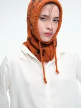 Camisa de corte oversize color bordó, con cuello clásico, cierre frontal de botones y mangas largas amplias con puños anchos. Presenta un diseño de caída fluida con bajo redondeado y levemente más largo en la parte posterior.