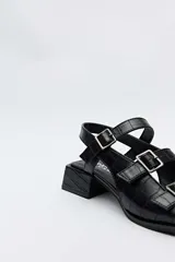 Sandalias de taco bajo cuadrado color negro con textura efecto cocodrilo, punta cuadrada y múltiples tiras cruzadas en el empeine con hebillas metálicas plateadas.