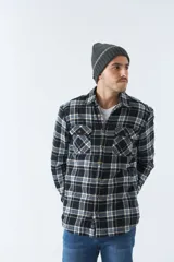 Sobrecamisa de algodón a cuadros color ladrillo, con interior de corderito, cierre con botones, bolsillos tipo cartera y logo en goma. El modelo usa talle M.