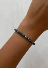 Pulsera de cristalitos facetados en tonos azules, intercalados con pequeñas cuentas y cierre de acero.