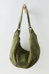 Bolso tote tipo hobo confeccionado en ante suave color verde militar, con diseño de cuerpo blando, cierre superior con cremallera y asas largas para llevar al hombro unidas mediante anillas metálicas.