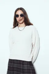 Sweater negro de tejido texturizado con líneas horizontales en relieve, de silueta levemente holgada y hombros caídos.