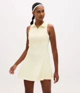 Vestido deportivo Get Over de microfibra color amarillo claro, sin mangas, con cuello polo y escote en V. Presenta diseño evasé con short interno incorporado que incluye bolsillo lateral. Confeccionado en poliamida y elastano.