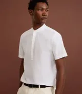 Camisa de manga corta confeccionada en mezcla de lino y algodón, con cuello tipo padre y cierre frontal parcial con botones.