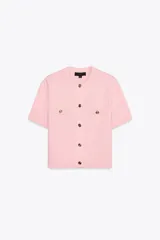 Chaqueta de punto color amarillo pálido, con cuello redondo, manga corta, cierre frontal con botones dorados y bolsillos de parche en el pecho.