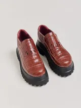 Mocasines color marrón con estampado de cocodrilo y plataforma negra con suela dentada.