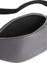 Riñonera gris de cuero sintético reciclado con logo CK grabado en el frente. Tiene correa de jacquard ajustable con logo y cierre superior con cremallera.