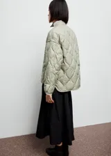 Campera acolchada de diseño oversize en color verde claro, con cuello redondo, cierre frontal de botones a presión y manga larga.