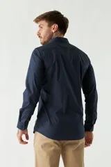 Camisa de vestir azul marino, de corte slim fit, manga larga y cuello clásico. Confeccionada en algodón y con logo bordado en el pecho.