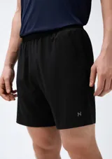 Bermuda deportiva de color negro, con cintura elástica y bolsillos laterales. Presenta un pequeño logo reflectante en la parte inferior de la pierna.