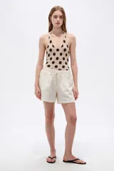 Short de lino color blanco de tiro medio, con bolsillos laterales y cintura elástica con cordón de ajuste.