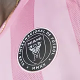 Camiseta de fútbol Adidas del Inter Miami CF, modelo 25/26. Diseño a rayas verticales rosas y blancas con detalles en negro en cuello, mangas y hombros. Incluye logo de Adidas, escudo del club y sponsor Royal Caribbean en el frente.