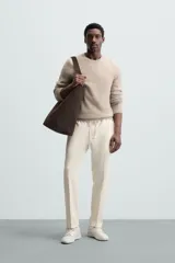 Pantalón regular fit color negro de tejido con viscosa, con cintura elástica ajustable con cordón, bolsillos frontales y traseros.