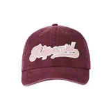 Gorra Rip Curl estilo dad hat de color bordó, con visera curva y parche frontal bordado con el logo de la marca en tonos rosado y blanco con relieve.